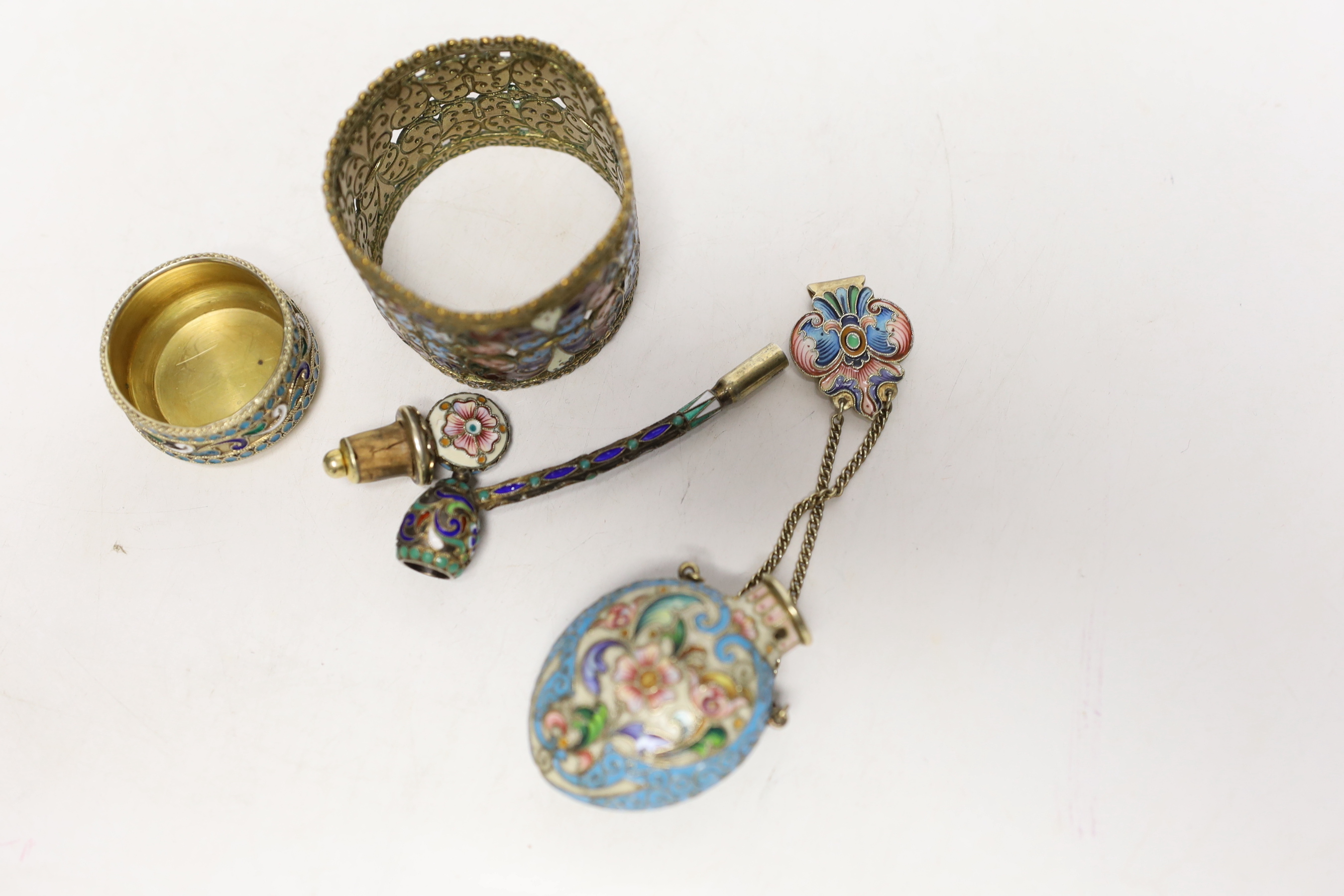 A late 19th/early 20th century Russian gilt 84 zolotnik and polychrome enamel pipe, 73mm, similar later scent bottle and salt and a brass? and enamelled napkin ring.